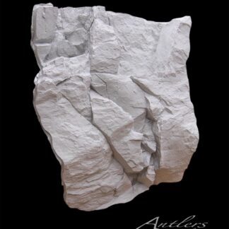 A jagged, light-gray Reproduction Rock with layered, uneven surfaces is set against a solid black background. “Antlers by Klaus” is written in cursive at the bottom right corner.